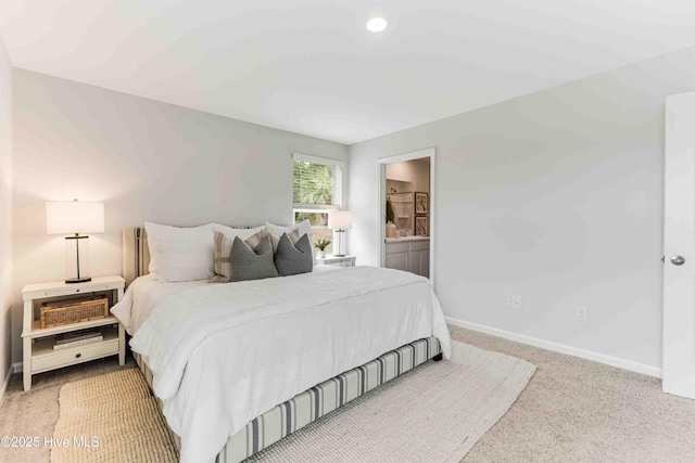 carpeted bedroom featuring baseboards and ensuite bathroom