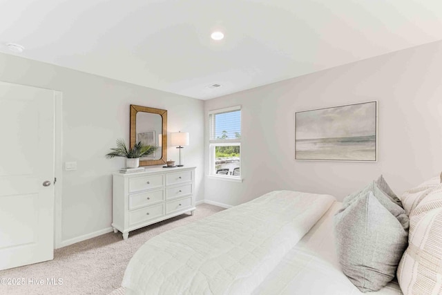 bedroom featuring light colored carpet and baseboards