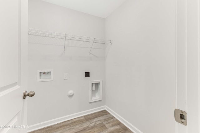 laundry area featuring washer hookup, gas dryer hookup, wood finished floors, laundry area, and baseboards