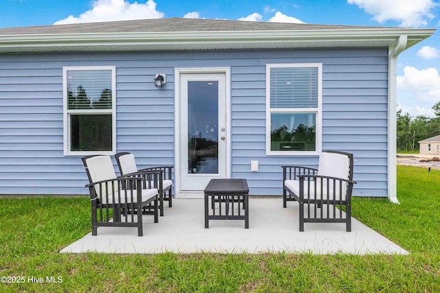 back of property with a yard and a patio