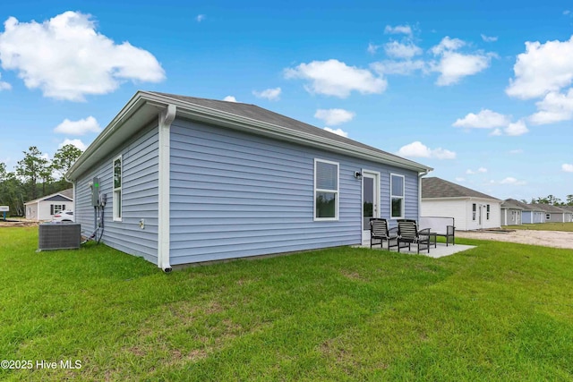 back of property with central AC, a yard, and a patio