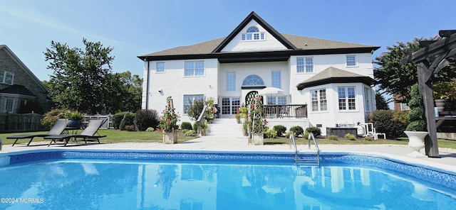 back of property featuring a patio, stairway, fence, and a fenced in pool