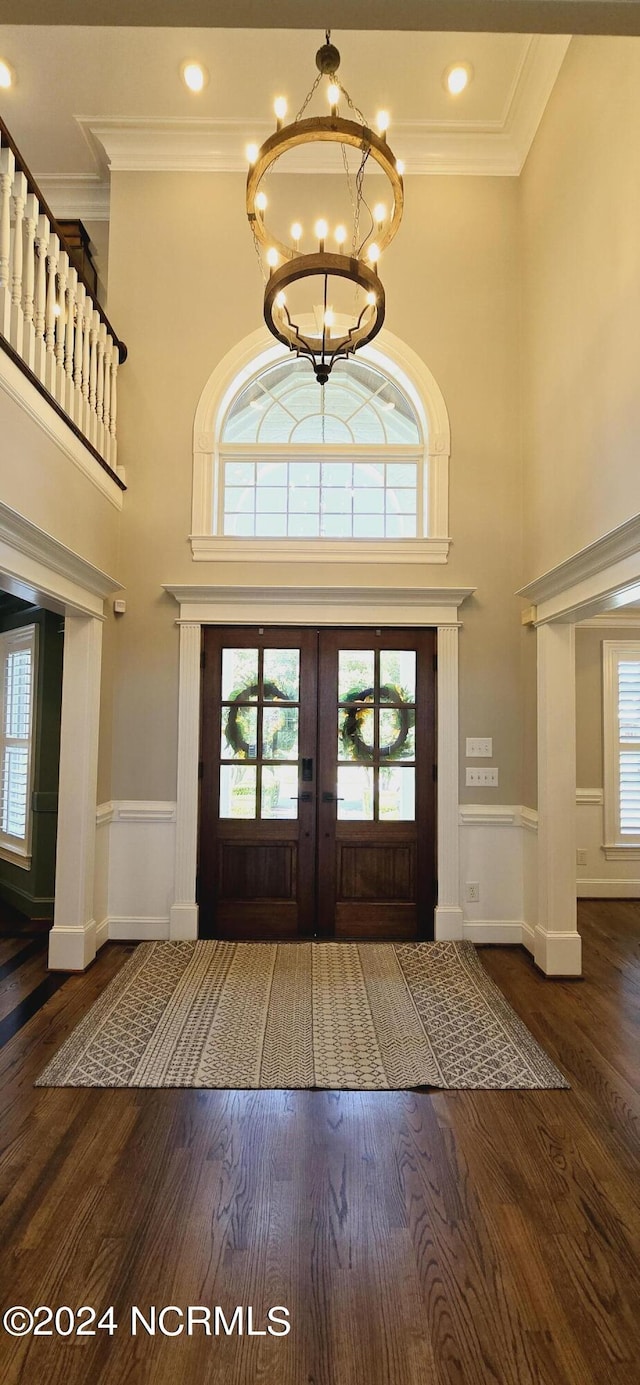 entrance foyer featuring a chandelier, wainscoting, wood finished floors, and a healthy amount of sunlight