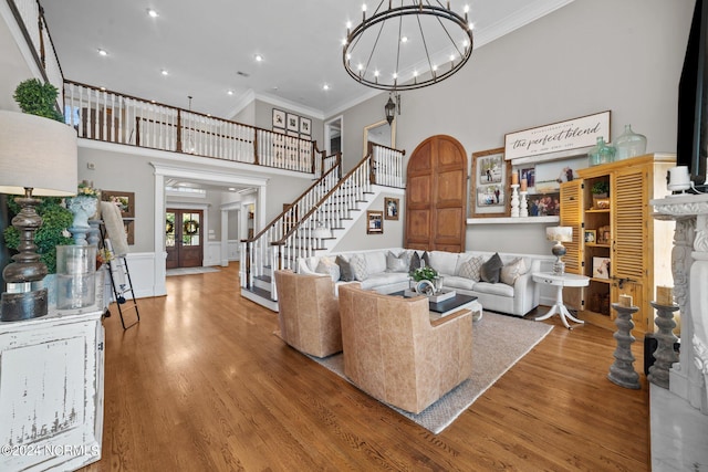 living room with stairs, a high ceiling, wood finished floors, and a stone fireplace