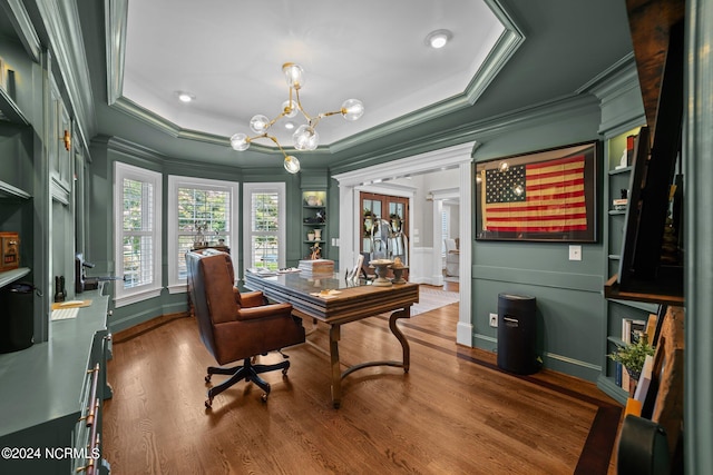 office space featuring dark wood-style floors, ornamental molding, a decorative wall, and an inviting chandelier