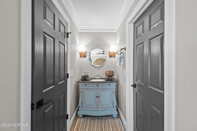 bathroom featuring crown molding, vanity, and baseboards