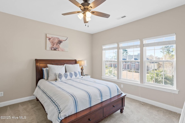 bedroom featuring baseboards, multiple windows, visible vents, and light colored carpet