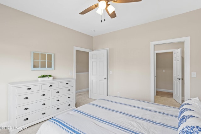 bedroom with a ceiling fan, light colored carpet, and baseboards