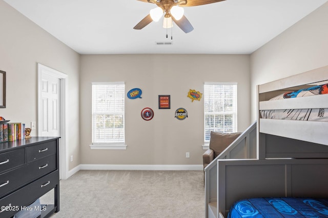 bedroom featuring multiple windows, baseboards, and light colored carpet