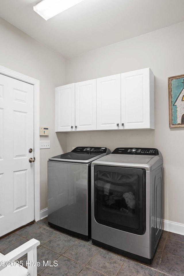 laundry room featuring cabinet space, baseboards, and separate washer and dryer