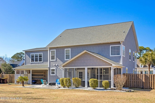 back of property featuring a sunroom, a patio, fence, and a lawn