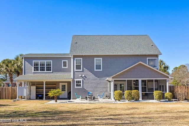 rear view of house featuring a yard, a patio area, fence, and a sunroom