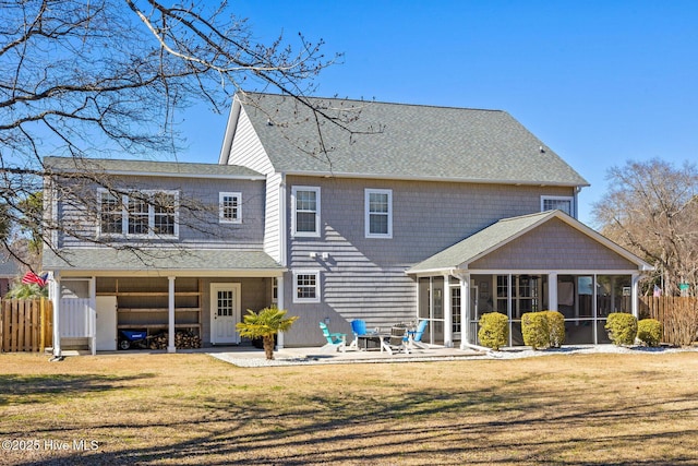 back of property with a sunroom, fence, a lawn, and a patio