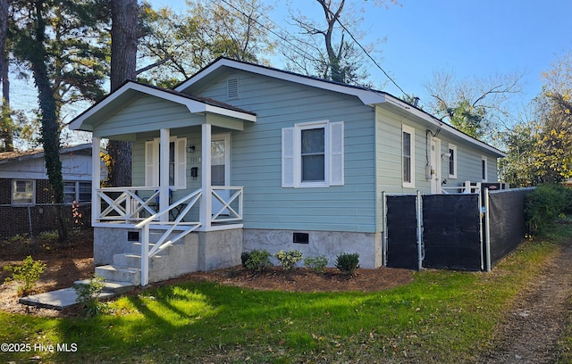 view of front of house with crawl space, covered porch, a front lawn, and fence