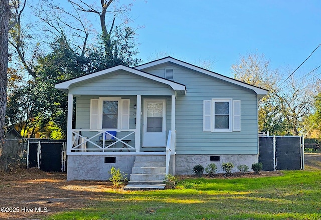 view of front of property with a porch, fence, a front lawn, and crawl space