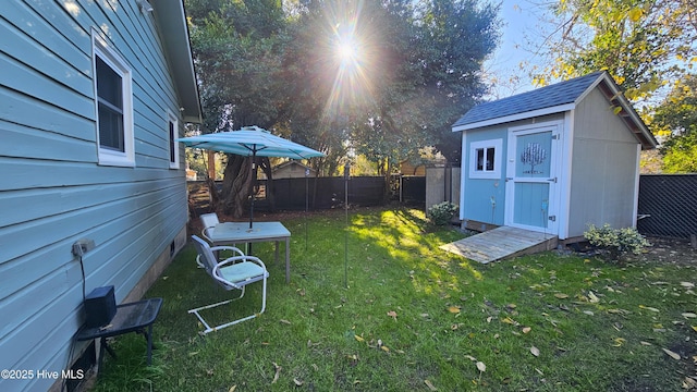 view of yard with an outdoor structure, a fenced backyard, and a shed