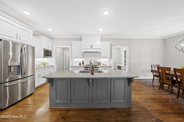 kitchen with dark wood-style flooring, white cabinetry, stainless steel appliances, and a sink