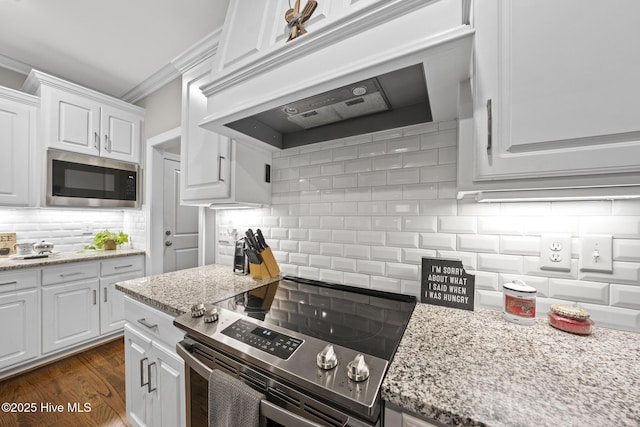 kitchen with tasteful backsplash, stainless steel appliances, crown molding, under cabinet range hood, and white cabinetry