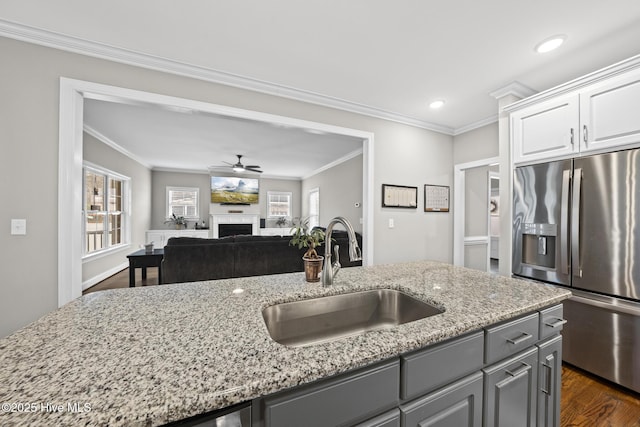 kitchen with gray cabinetry, a fireplace, a sink, and stainless steel fridge with ice dispenser