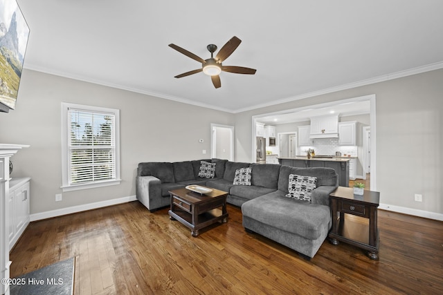 living room featuring baseboards, ornamental molding, and dark wood-type flooring