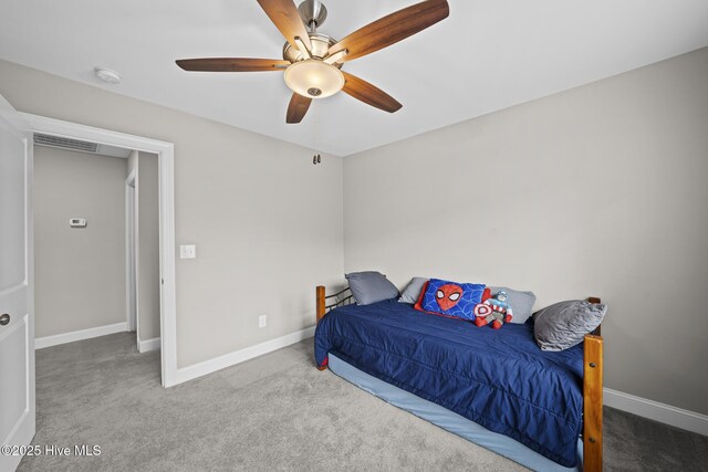 carpeted bedroom featuring a ceiling fan, visible vents, and baseboards