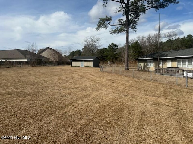 view of yard featuring fence and an outdoor structure