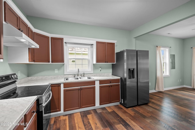 kitchen with dark wood-style flooring, stainless steel appliances, light countertops, and a sink