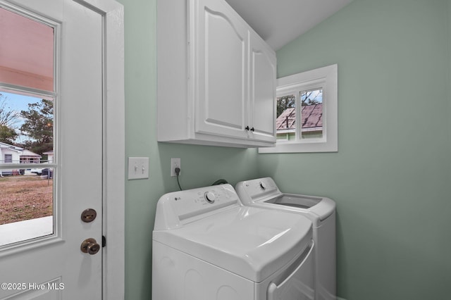 washroom with a healthy amount of sunlight, cabinet space, and washer and clothes dryer