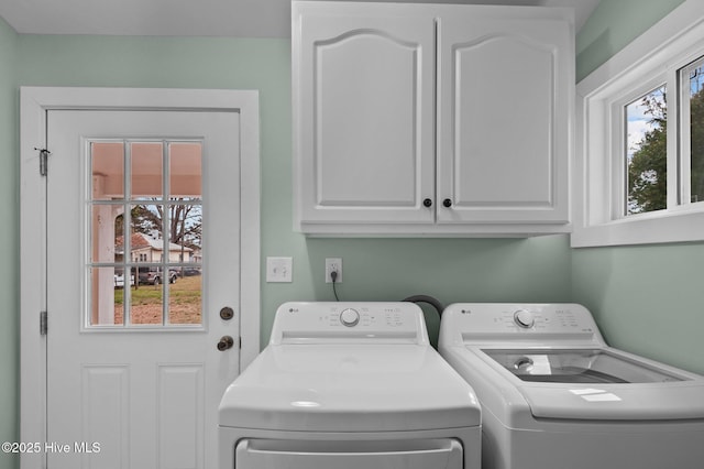 clothes washing area featuring cabinet space and washing machine and dryer