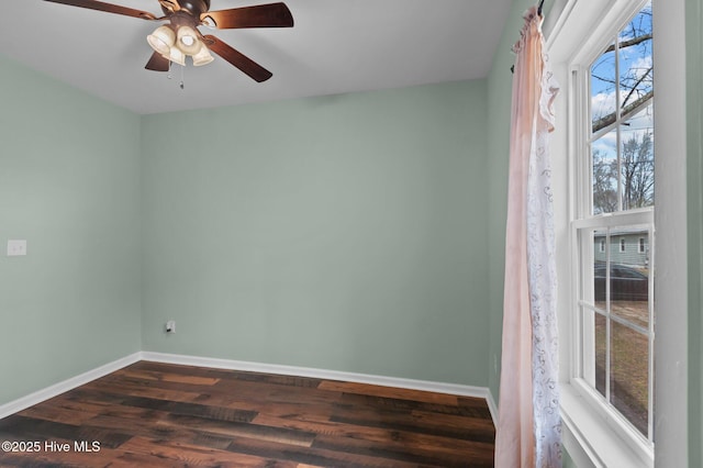 spare room with a ceiling fan, baseboards, and dark wood-style flooring