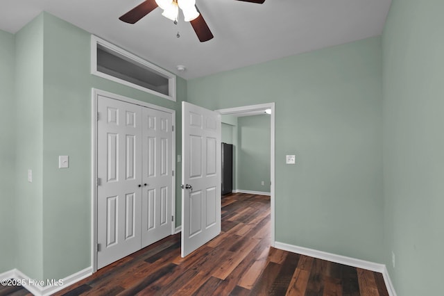 unfurnished bedroom featuring a ceiling fan, wood finished floors, baseboards, and a closet