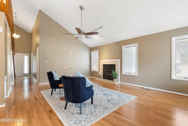 living room with a tile fireplace, visible vents, light wood-style flooring, and baseboards