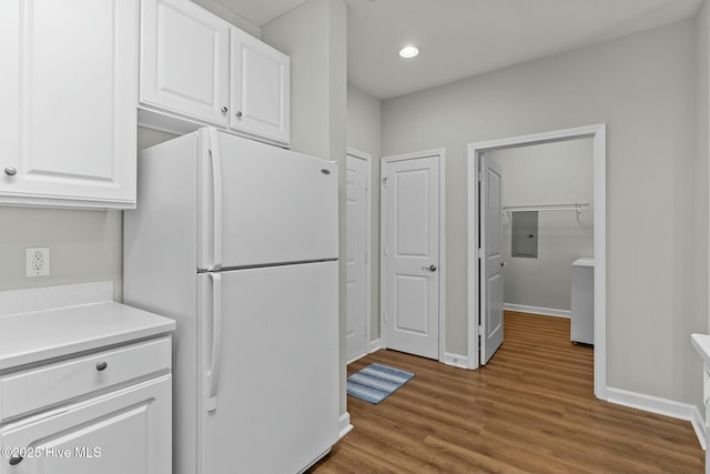 kitchen with baseboards, wood finished floors, freestanding refrigerator, light countertops, and white cabinetry