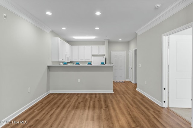 kitchen with white appliances, baseboards, crown molding, white cabinetry, and recessed lighting