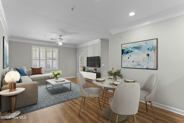 living room featuring baseboards, a ceiling fan, wood finished floors, crown molding, and recessed lighting