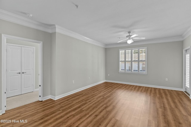 unfurnished room with a healthy amount of sunlight, baseboards, ornamental molding, and wood finished floors