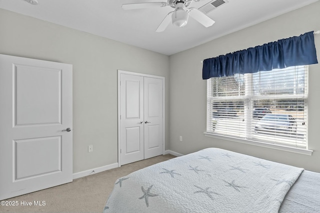 carpeted bedroom featuring a ceiling fan, visible vents, baseboards, and a closet