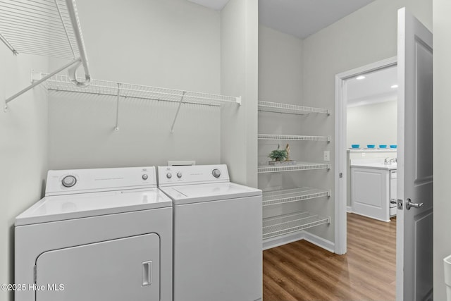 laundry room featuring laundry area, washer and clothes dryer, and wood finished floors