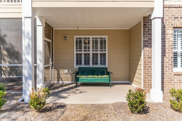 view of exterior entry featuring brick siding