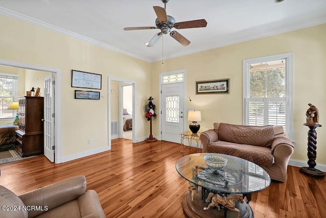 living area featuring ornamental molding, wood finished floors, visible vents, and baseboards