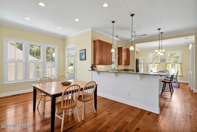 dining area featuring crown molding, baseboards, and hardwood / wood-style flooring