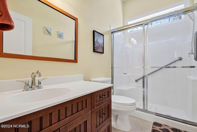 full bathroom featuring a stall shower, vanity, toilet, and tile patterned floors