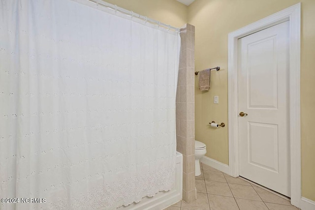 bathroom with toilet, baseboards, and tile patterned floors