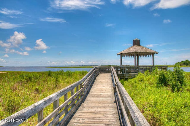 surrounding community with a water view and a gazebo