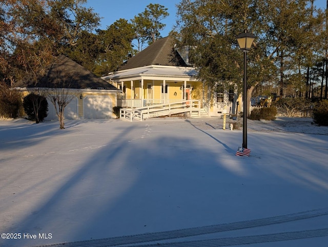 view of front of property with covered porch and a detached garage