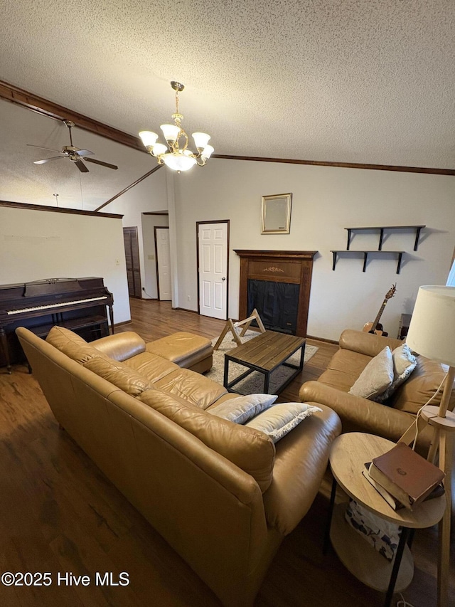 living room featuring lofted ceiling, a fireplace, a textured ceiling, and wood finished floors