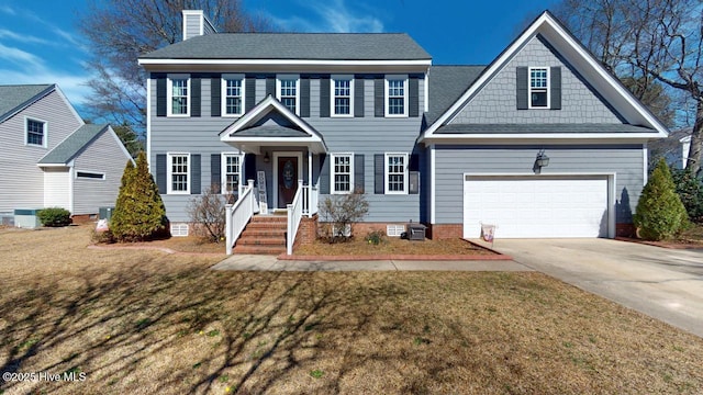 colonial inspired home with a chimney, a front yard, crawl space, a garage, and driveway