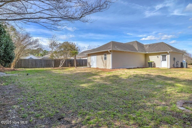 view of side of property with a yard, central AC, and fence