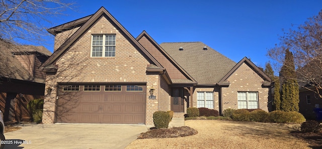 view of front facade with a garage, a shingled roof, concrete driveway, and brick siding