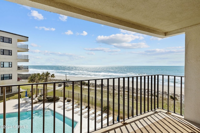 balcony featuring a water view and a beach view